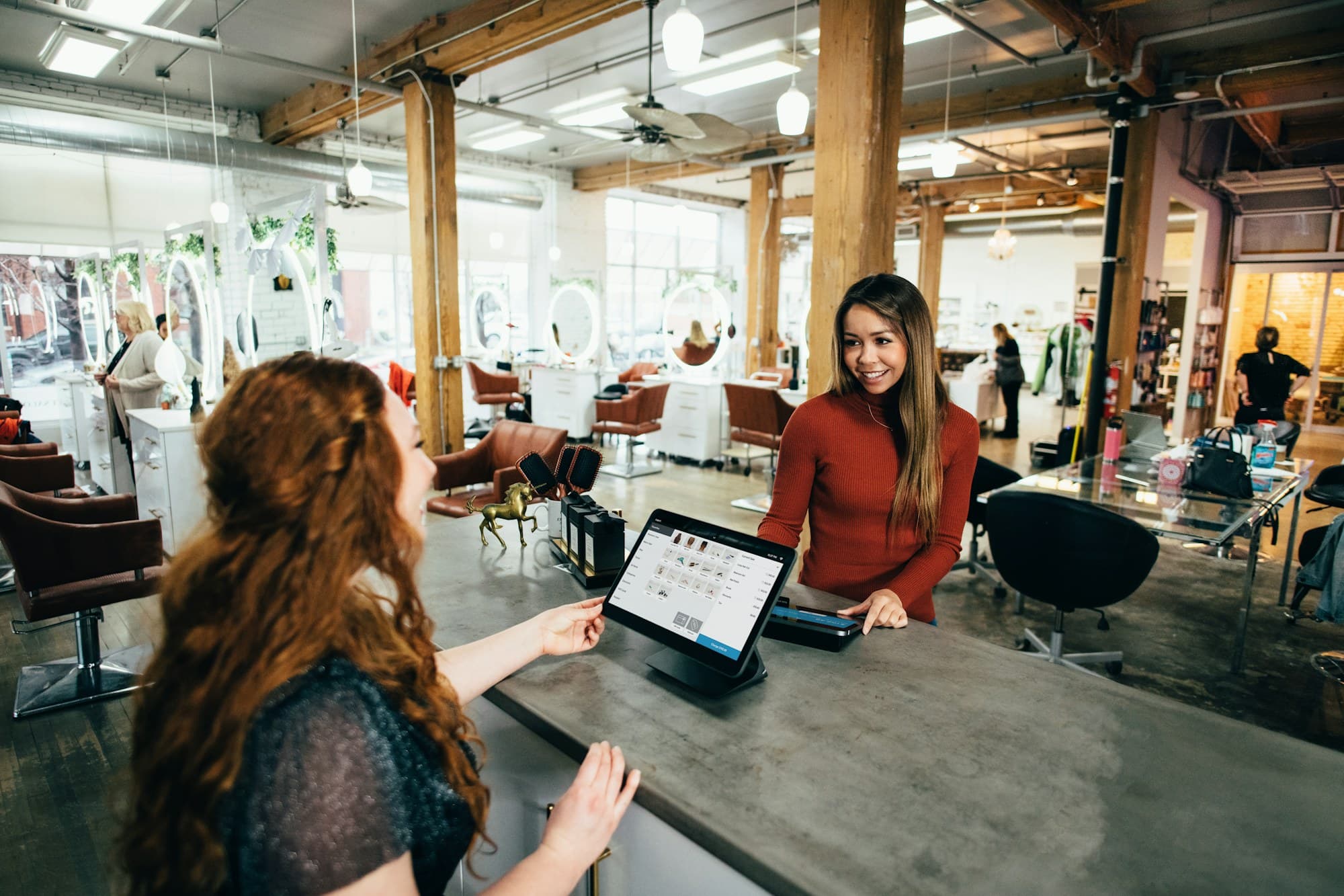 Staff member assisting a customer at a point-of-sale touchscreen